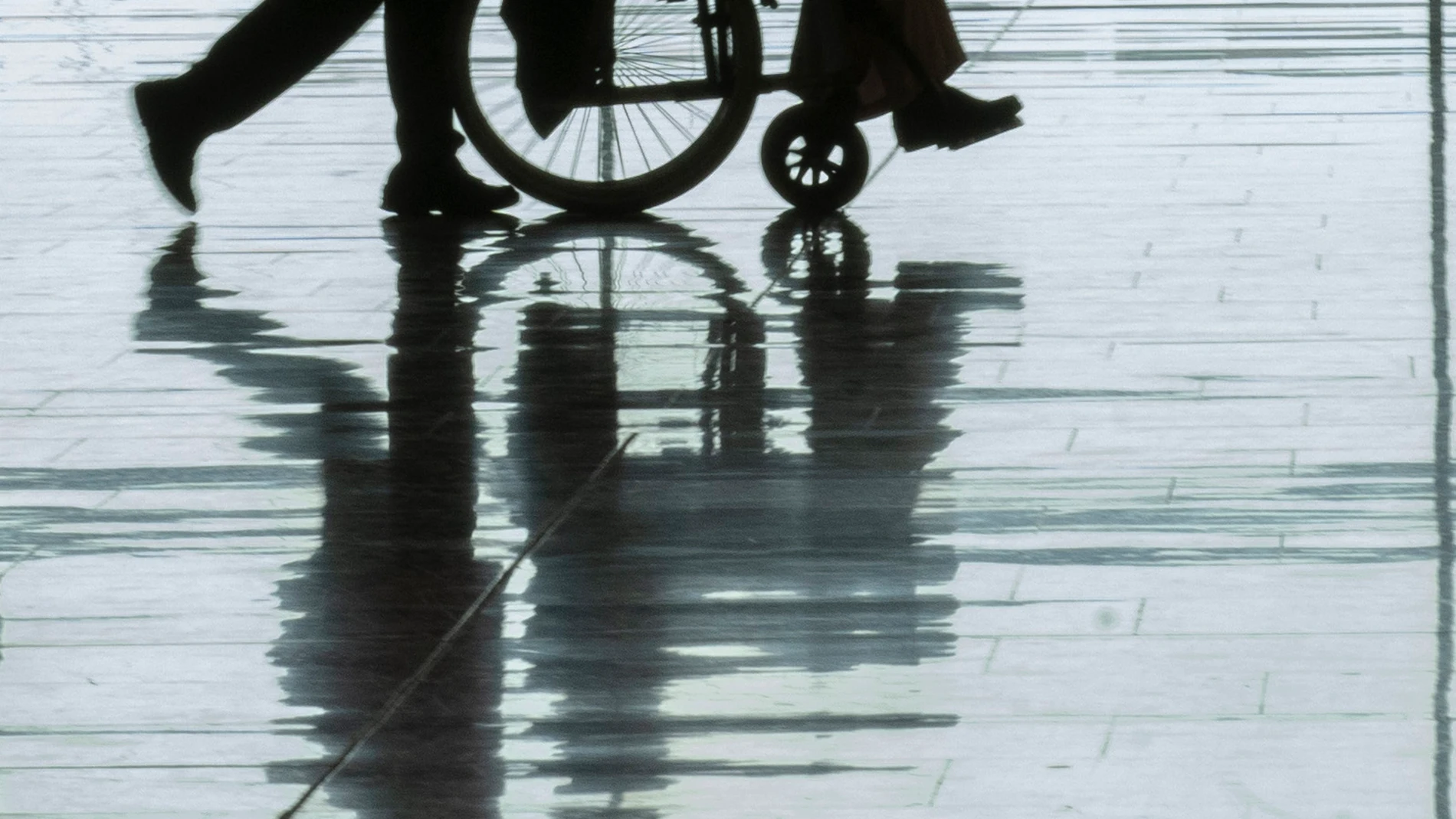 Minusválido acompañado por personal del Aeropuerto Adolfo Suárez de Madrid Barajas.