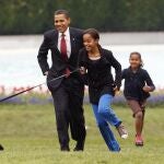 Barack Obama, jugando con sus hijas Sasha y Malia en los jardines de la Casa Blanca