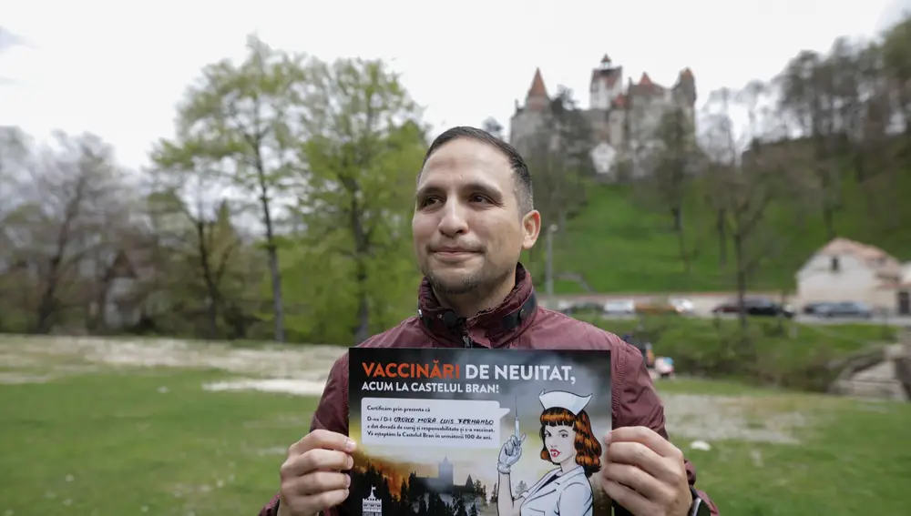 Fernando Orozco posa con un anuncio que anima a la gente a vacunarse en el castillo del Bram