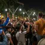 Varios jóvenes reunidos en ambiente festivo en una calle de Barcelona el sábado noche