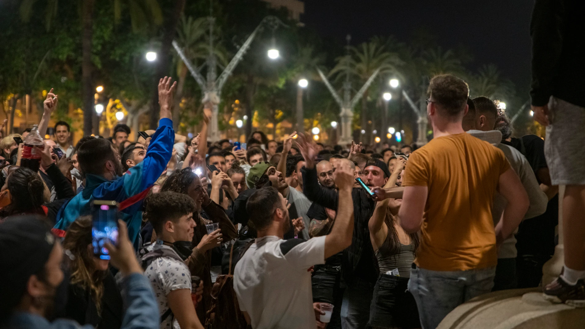 Varios jóvenes reunidos en ambiente festivo en una calle de Barcelona el sábado noche