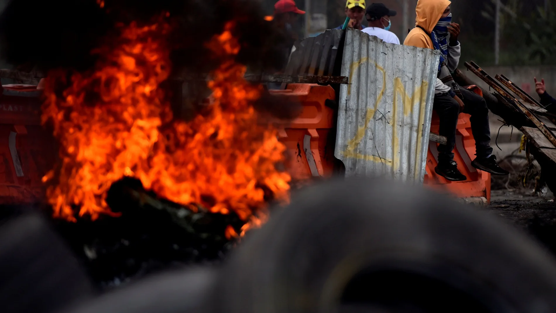 Un grupo de manifestantes incendian neumáticos y bloquean una calle en Cali (Colombia)