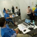 GRAFCAT3016. BARCELONA, 11/05/2021.- Un enfermero vacuna a un hombre en el centro de vacunación de la Fira de Barcelona, donde se vacuna a personas de 55 a 59, a un ritmo de 6.000 inyecciones diarias, este martes, cuando la cuarta ola del coronavirus sigue descendiendo en Cataluña, que completa 11 días seguidos de mejora de los indicadores, con una positividad que hoy ha bajado por primera vez del 5 %, aunque las UCI siguen llenas con 442 pacientes graves de COVID, uno más que ayer, y se han superado las 22.000 víctimas mortales en esta comunidad. EFE/Enric Fontcuberta