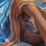 Una paciente aislada por un posible caso positivo de covid-19 recibe oxigenoterapia este martes en un hospital de Ahmedabad, India.