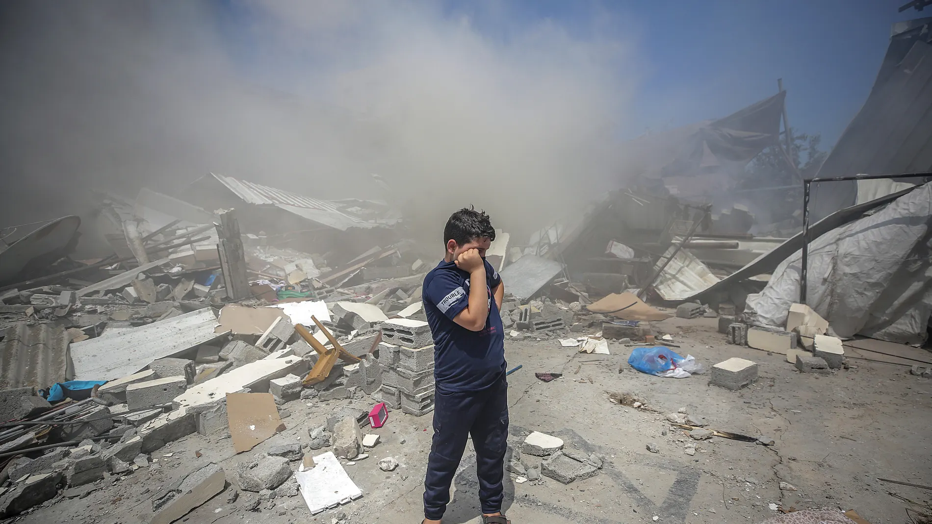 Un niño palestino sobre los escombros de su casa destruida tras un ataque israelí en la ciudad de Gaza