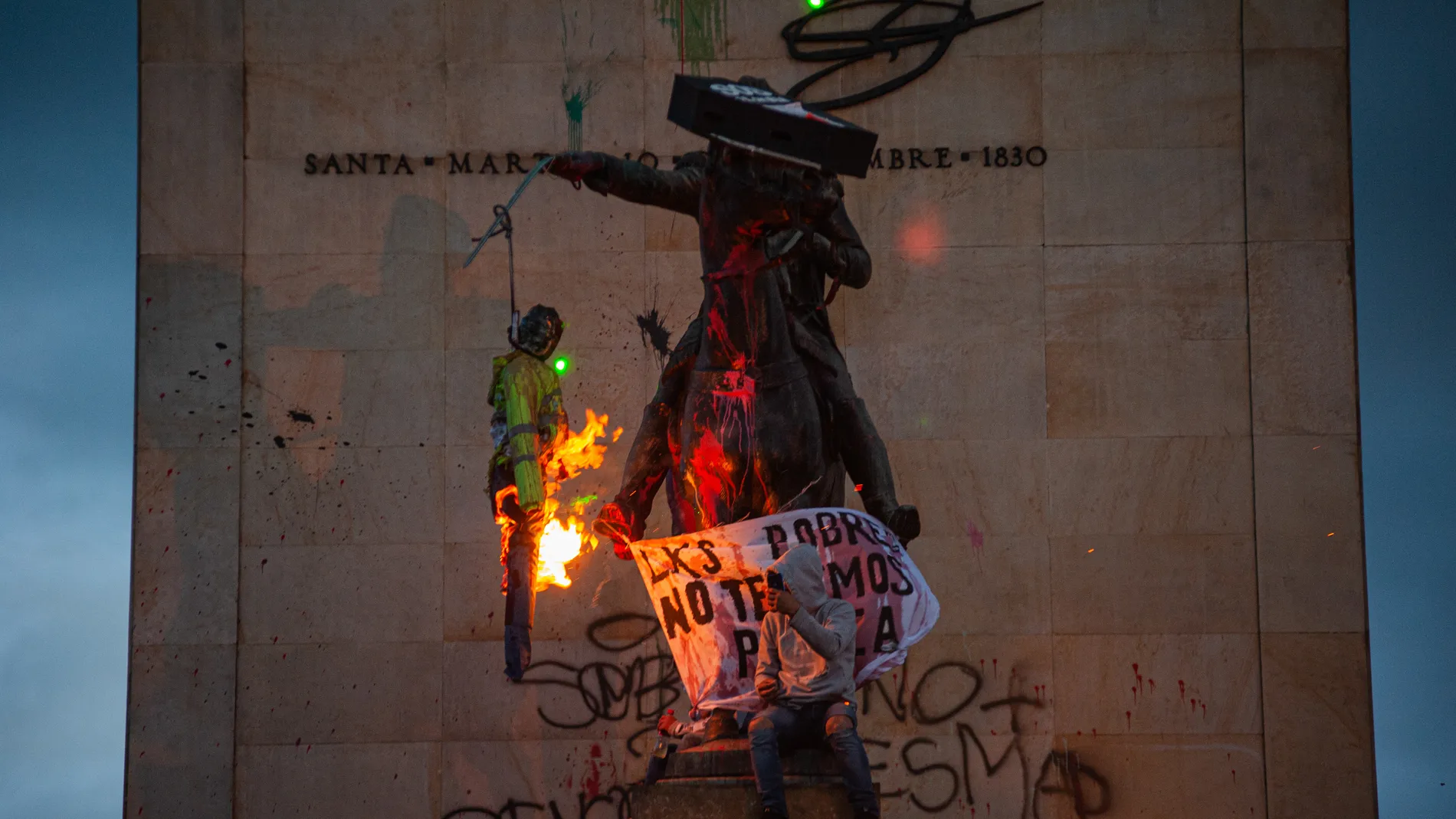 Manifestantes en Colombia prenden fuego a una marioneta en una protesta en Bogotá