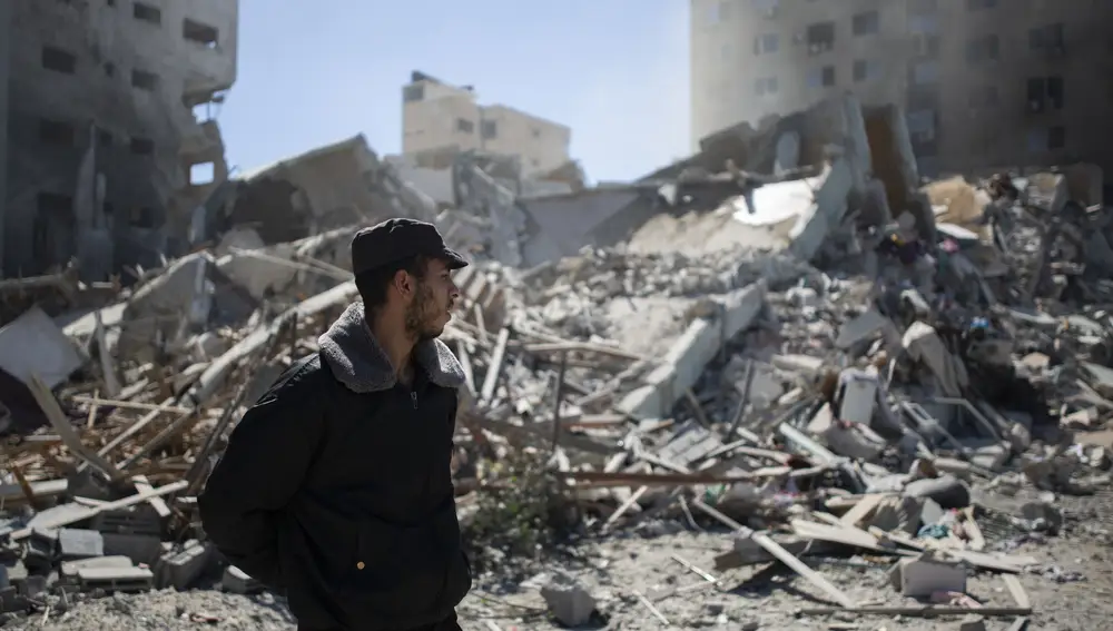 Un policía palestino entre los escombros de un edificio destruido por un ataque aéreo israelí que albergaba las oficinas de AP y Al Jazeera