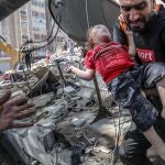 Un padre saca a su hija muerta de entre los escombros después de un ataque de la aviación israelí, en Ciudad de Gaza