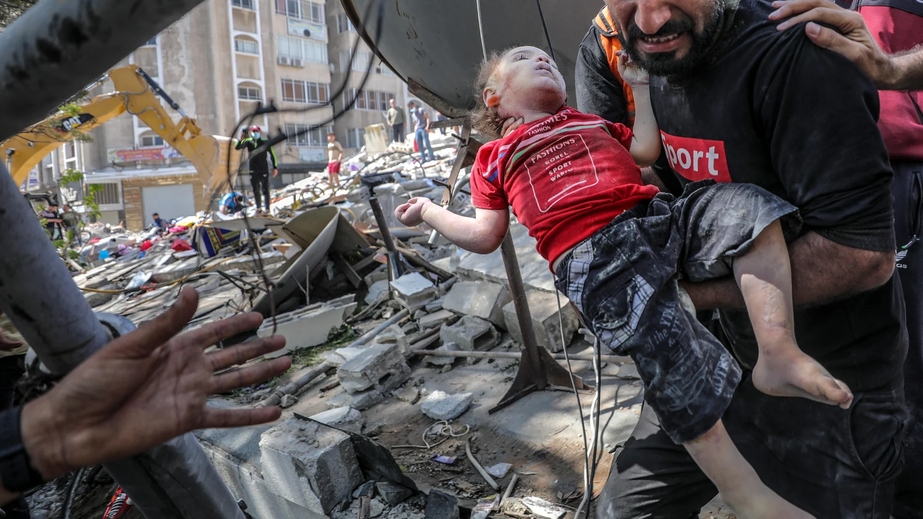 Un padre saca a su hija muerta de entre los escombros después de un ataque de la aviación israelí, en Ciudad de Gaza