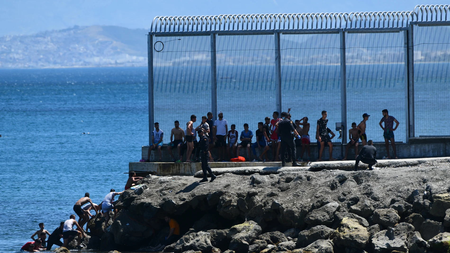 Un grupo de migrantes marroquíes entra en Ceuta por el espigón este lunes