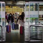 Unos viajeros abandonan el aeropuerto de Madrid-Barajas