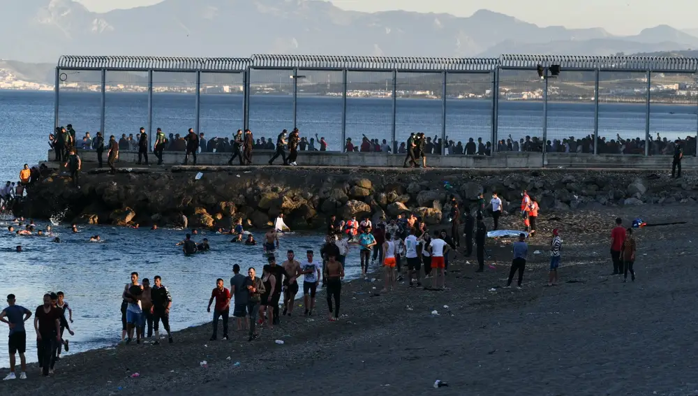 Migrantes caminan por la playa del Tarajal, el 17 de mayo de 2021, en Ceuta