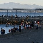 Migrantes caminan por la playa del Tarajal, el 17 de mayo de 2021, en Ceuta
