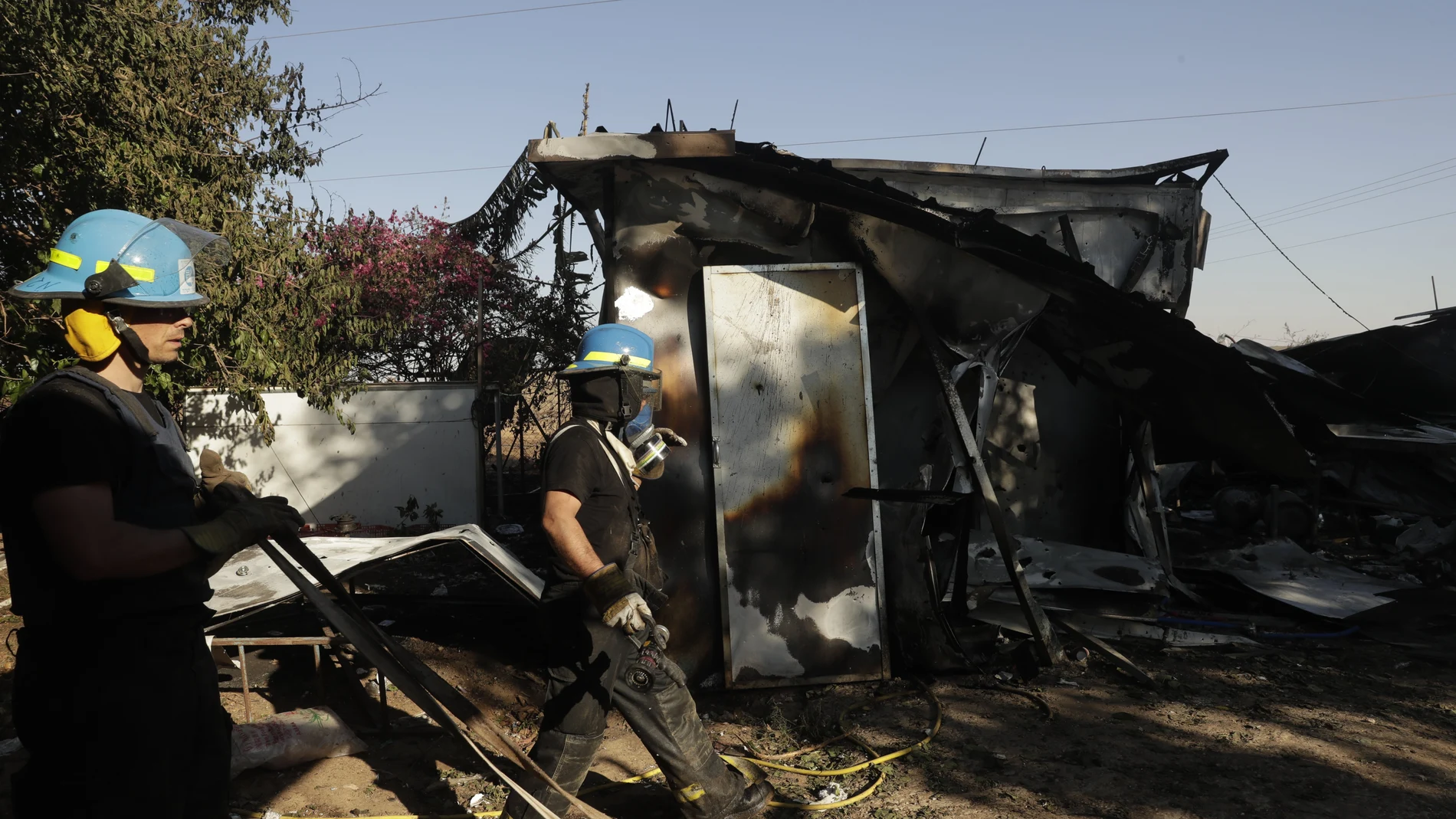 Los bomberos israelíes llegan al kibutz en el sur de Israel alcanzados por el lanzamiento de cohetes desde Gaza, que mataron a dos trabajadores tailandeses dentro de una planta de envasado en el sur de Israel