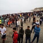 Cientos de personas esperan en la playa de la localidad de Fnideq (Castillejos) para cruzar los espigones de Ceuta en una avalancha de inmigrantes sin precedentes en España