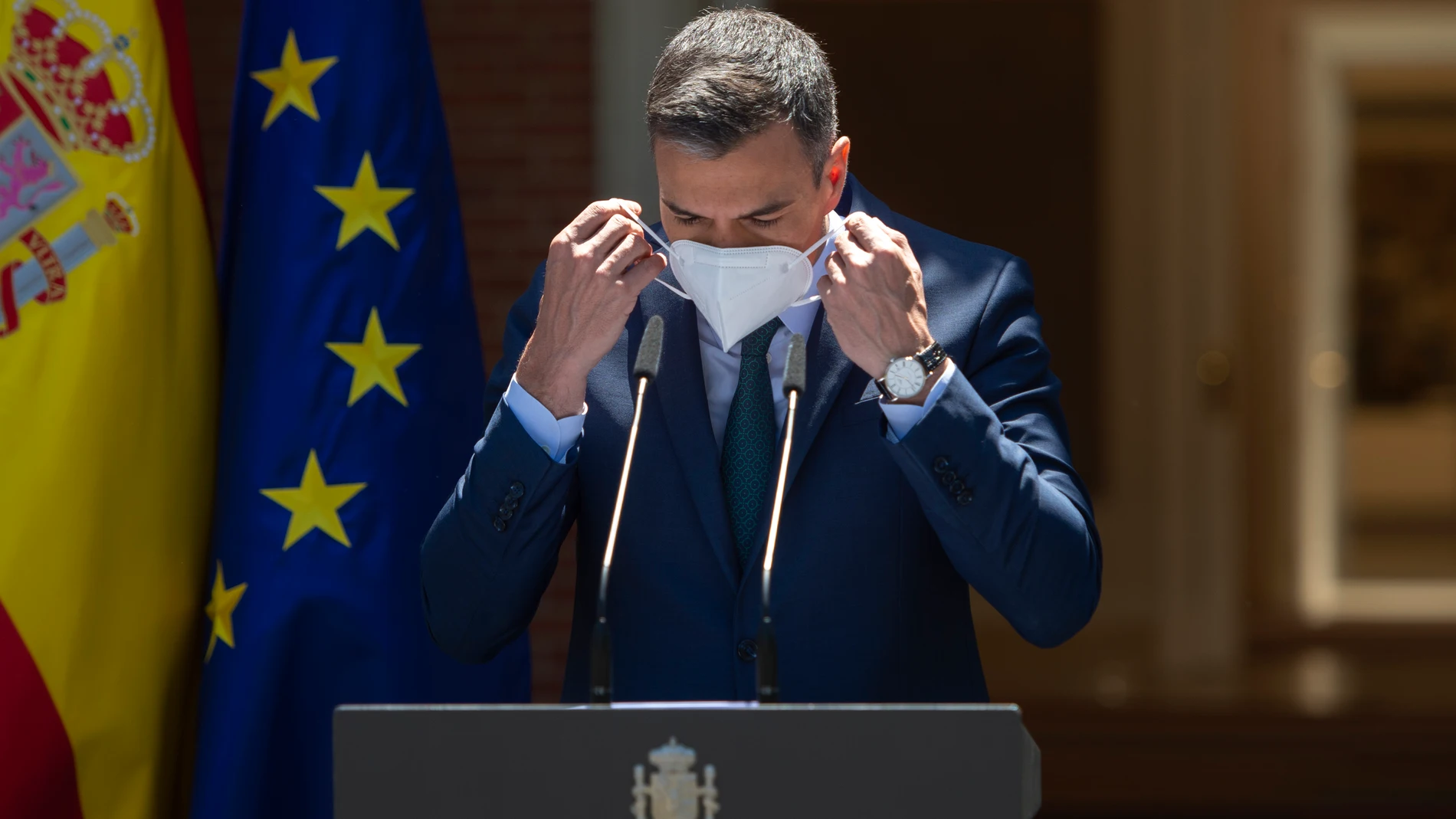 El presidente del Gobierno, Pedro Sánchez, se coloca la mascarilla para intervenir en una rueda de prensa