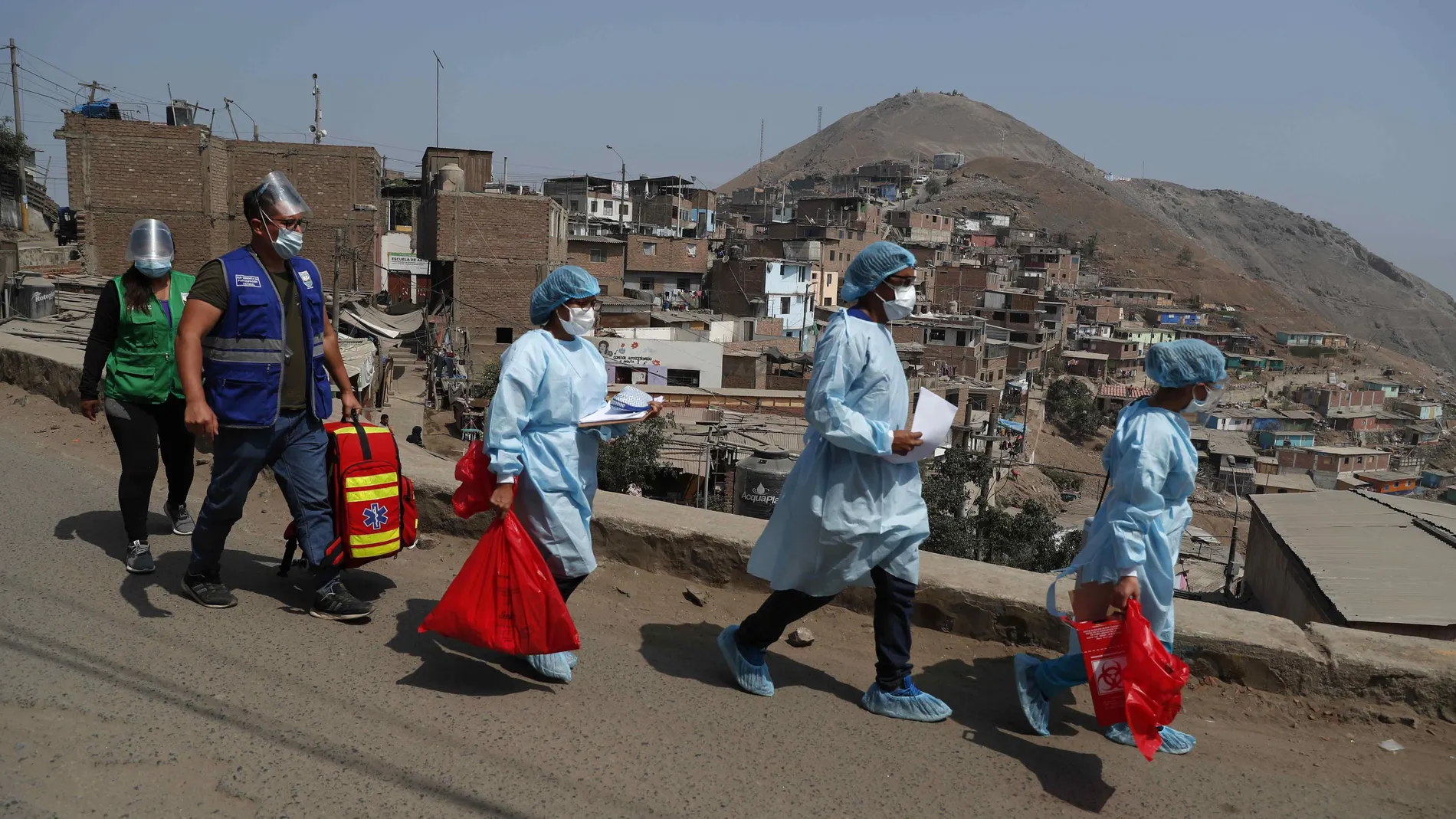 Personal de la salud encargado de vacunación contra la covid-19 llega el 14 de mayo de 2021 al "Cerro El Agustino" luego de ser subidos al lugar en mototaxi, en Lima (Perú)