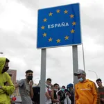 Varios migrantes esperan para pasar la frontera entre Ceuta y Marruecos
