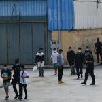 Agentes de la Policía Nacional acompañan a menores marroquíes a las naves acondicionadas anexas a la frontera del Tarajal en Ceuta