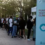 Varias personas hacen cola para someterse a un test de antígenos antes de participar en un ensayo sobre coronavirus en bares musicales en Barcelona