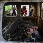 Niños palestinos observan el interior de un coche alcanzado por una bomba israelí en Gaza