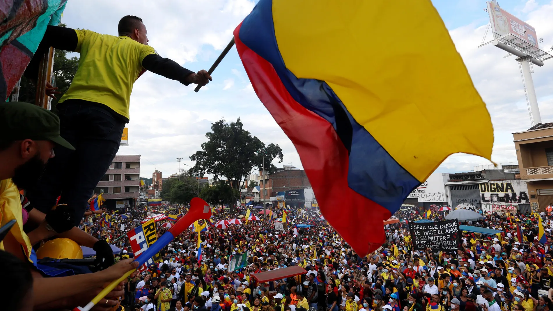 Un hombre ondea hoy una bandera colombiana durante una nueva jornada del Paro Nacional en contra del Gobierno de Iván Duque y la violencia policial, en Cali