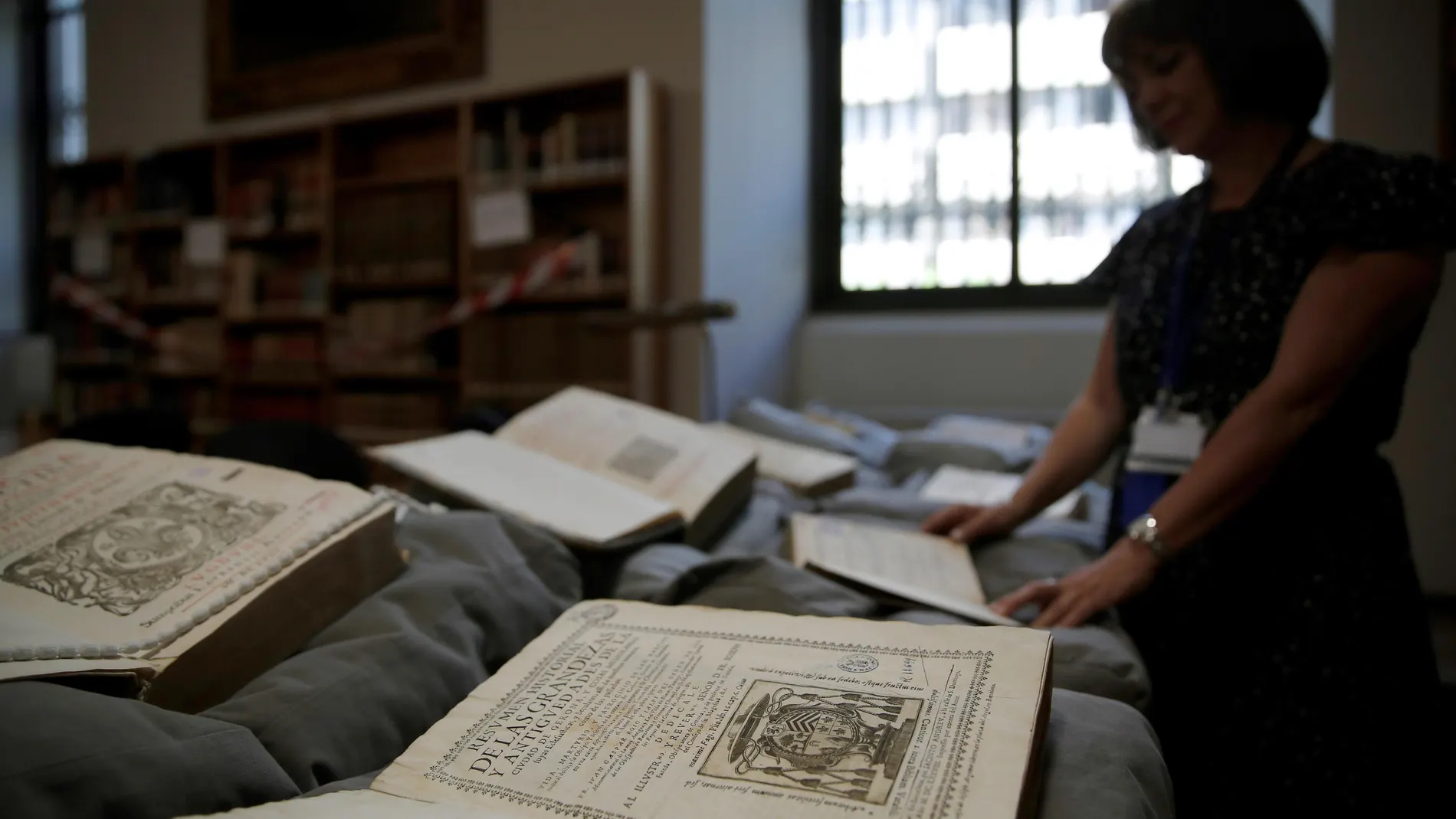 Una operaria despliega alguno de los 477 ejemplares devueltos por la Abadía del Valle de los Caídos a la Biblioteca Nacional este jueves. EFE/Juan Carlos Hidalgo