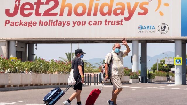 Varios turistas se dirigen a la terminal de salida del aeropuerto de Palma.
