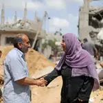 Dos palestinos se dan la mano después de regresar a sus casas destruidas tras la tregua entre Israel y Hamas, en Beit Hanoun, en el norte de la Franja de Gaza, hoy