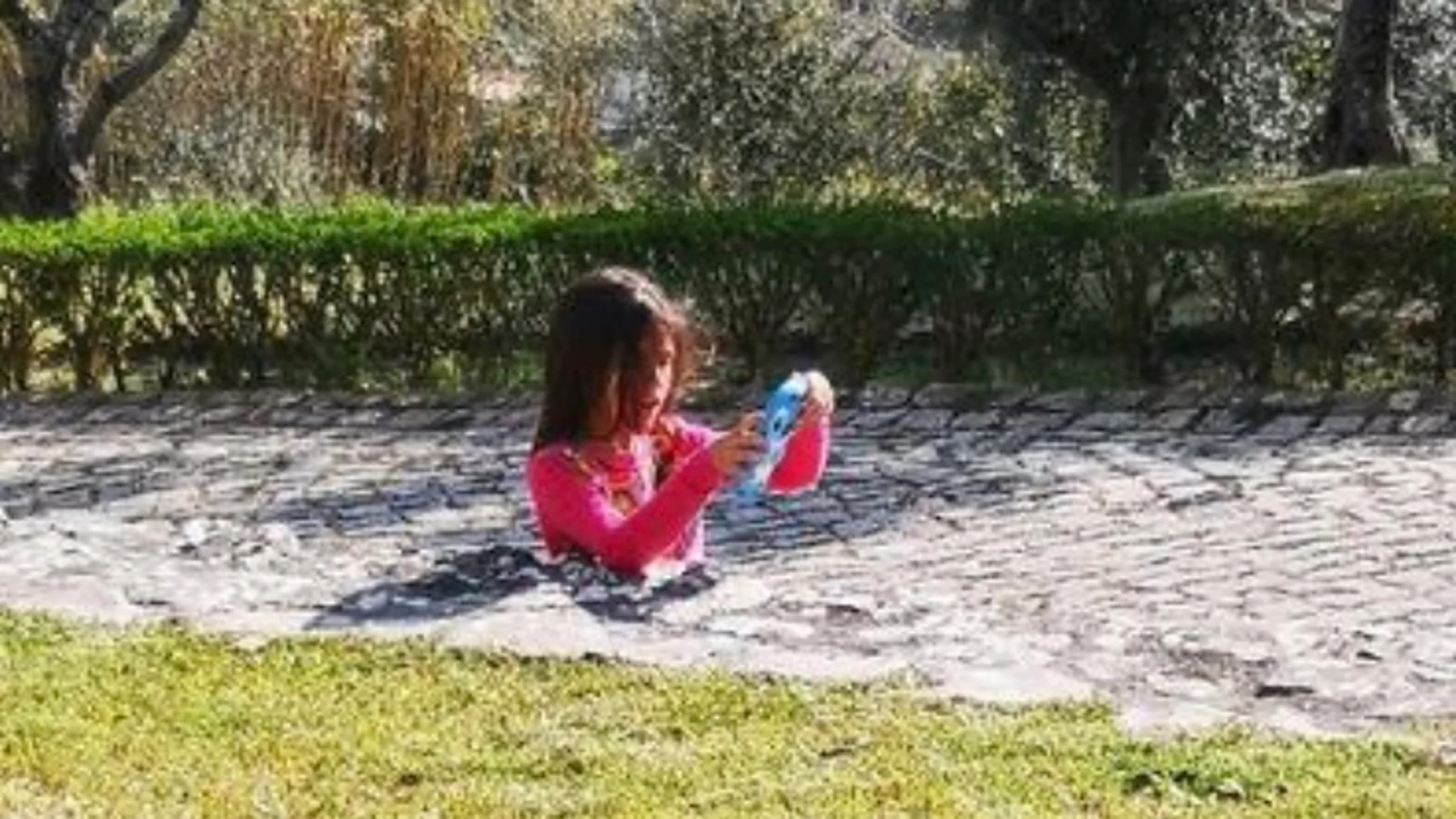 Una niña que aparentemente está enterrada entre el asfalto