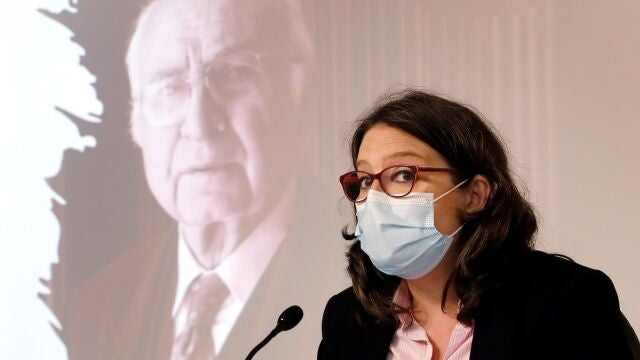 La vicepresidenta y portavoz del Consell, Monica Oltra, en presencia de una imagen del poeta Francisco Brines, fallecido este jueves a la edad de 89 años, durante la rueda de prensa tras la sesión plenaria semana del Gobierno valenciano