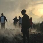 Varias personas caminan cerca de sus casas destruidas por la erupción del volcán Nyiragongo cerca de Goma