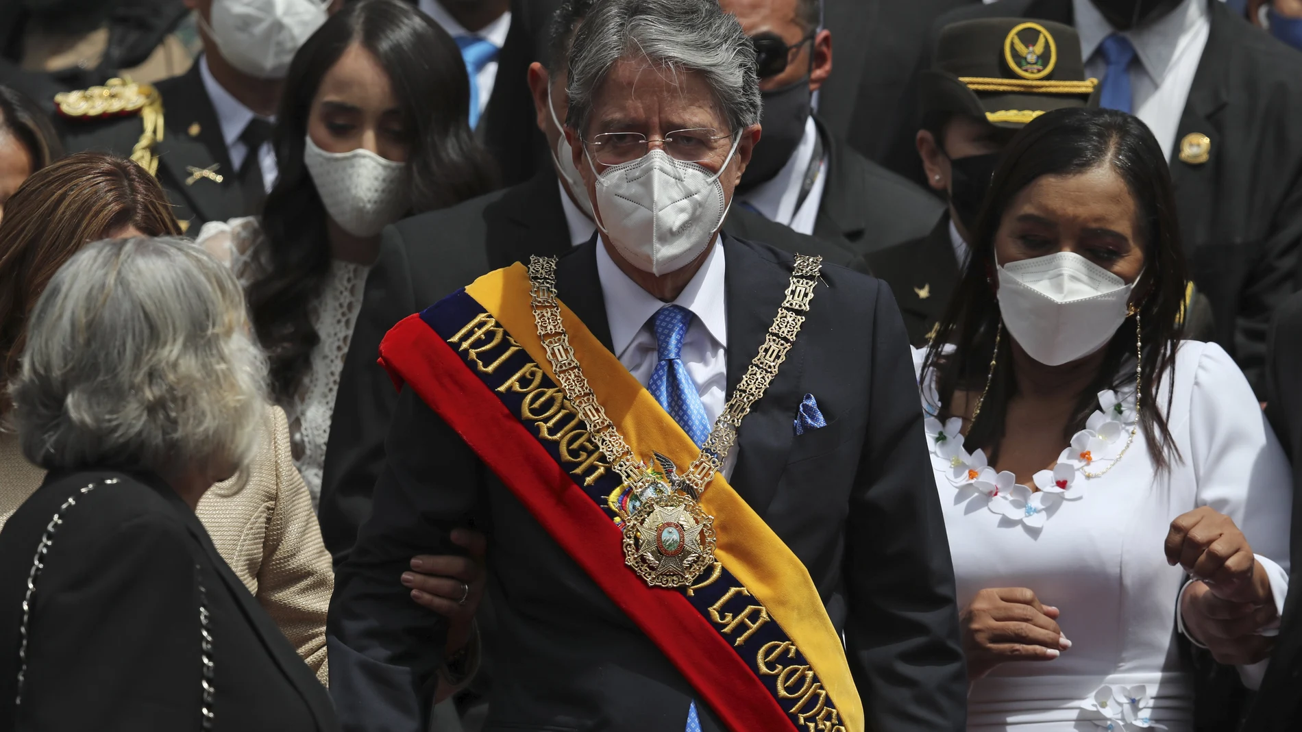 Ecuador's new President Guillermo Lasso wears the presidential sash after his inauguration ceremony as he exits the National Assembly with his wife Maria de Lourdes, partially covered left, and daughter Maria Mercedes, second from left, in Quito, Ecuador, Monday, May 24, 2021. At right is National Assembly President Guadalupe Llora. (AP Photo/Dolores Ochoa)