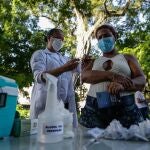 Una trabajadora de la salud aplica una dosis de la vacuna de AstraZeneca contra la covid-19 a una habitante de calle, en Río de Janeiro (Brasil).