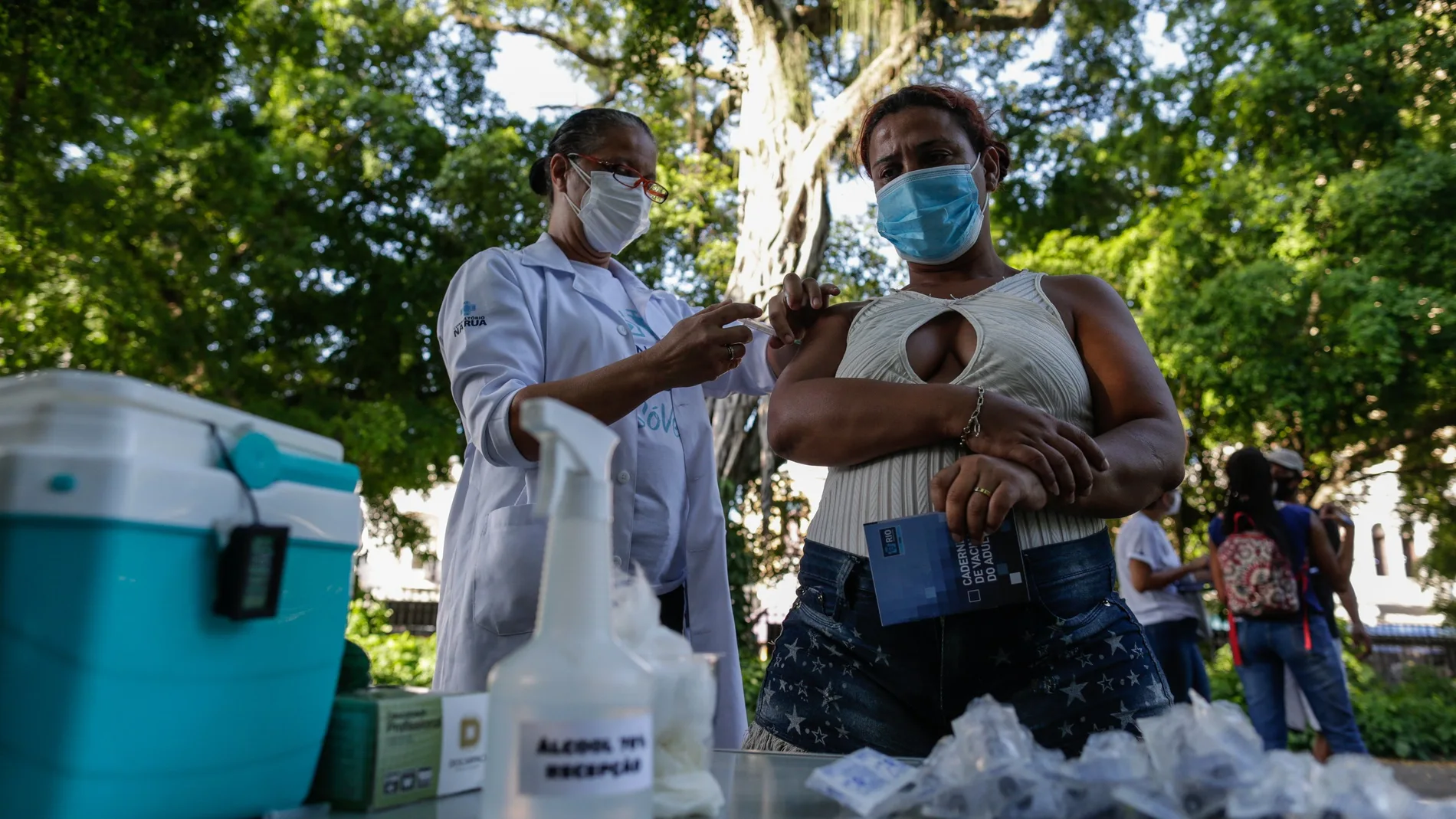 Una trabajadora de la salud aplica una dosis de la vacuna de AstraZeneca contra la covid-19 a una habitante de calle, en Río de Janeiro (Brasil).