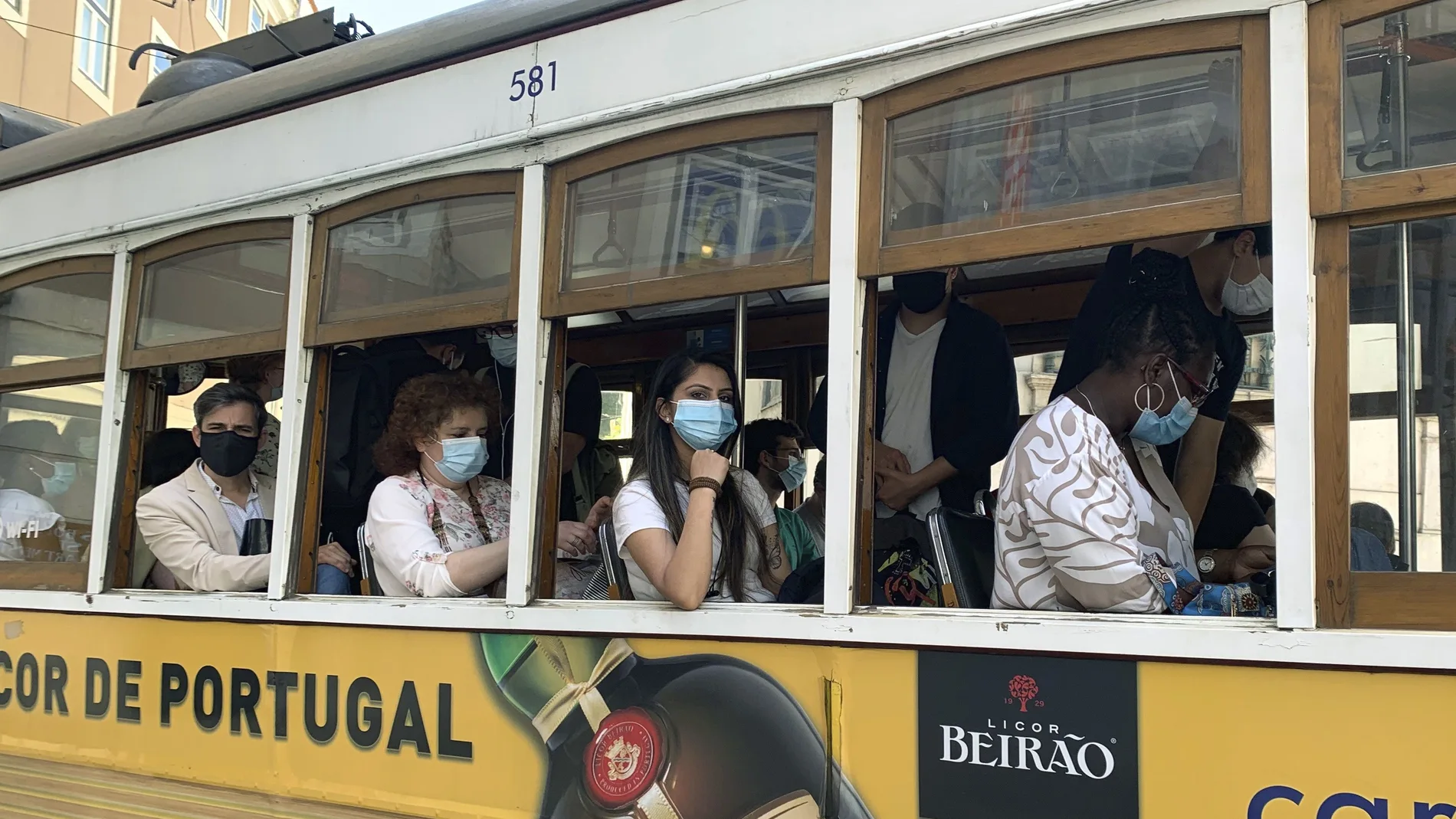Un grupo de pasajeros con mascarilla en un tranvía por la zona de la baixa de Lisboa