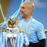 Pep Guardiola posa con el trofeo de la Premier League 2020-21 ganado por el Manchester City.