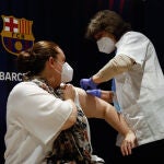 Una mujer recibe la primera dosis de la vacuna de Pfizer contra el Covid-19 en el Camp Nou