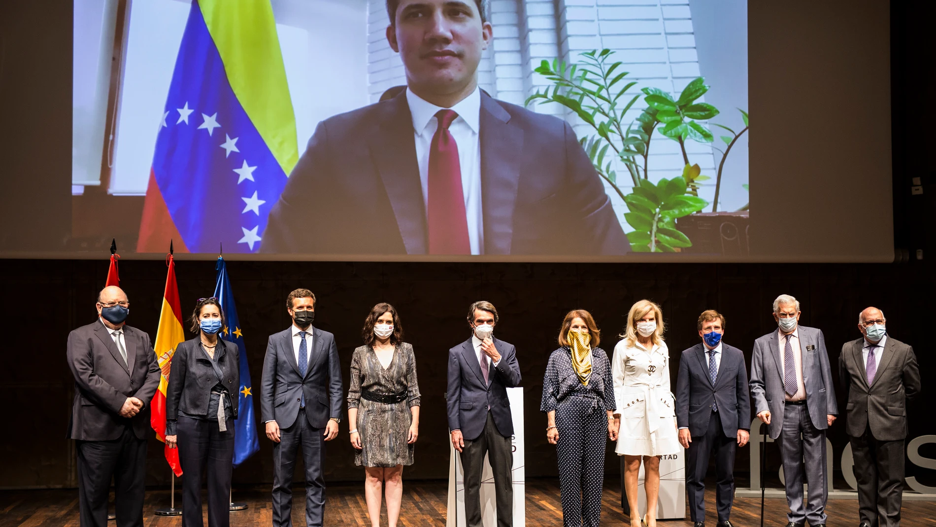 Foto de familia de los asistentes y del líder opositor venezolano Juan Guaidó por videoconferencia, durante la entrega del X Premio FAES de la Libertad