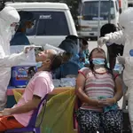 Trabajadores sanitarios tomando muestras en Filipinas (AP Photo/Aaron Favila)