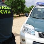 Agente de la Guardia Civil junto a su vehículo