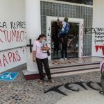 Varias personas pintan mensajes sobre las paredes y el piso del Palacio Federal durante unas protestas recientes en Acapulco, estado de Guerrero (México)