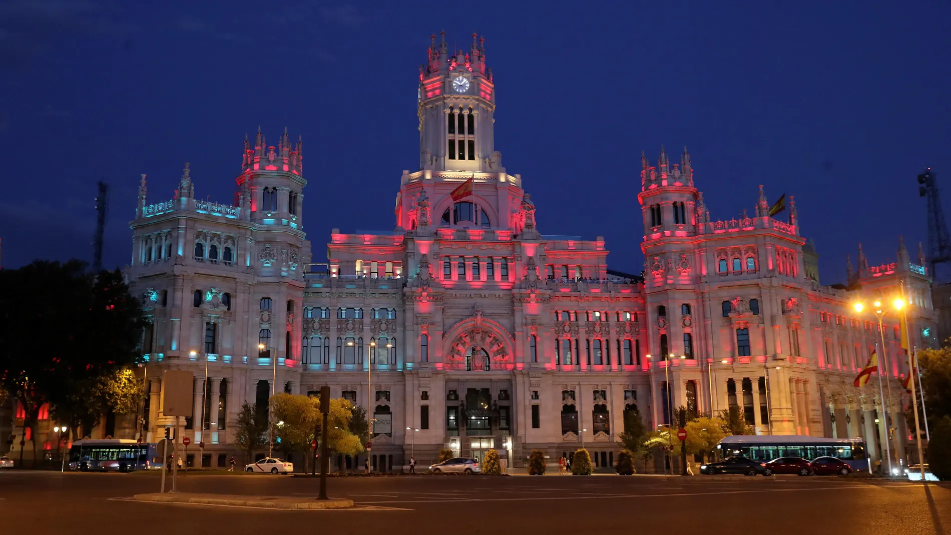 La fachada del Palacio de Cibeles, sede del Ayuntamiento de Madrid, iluminada con los colores de las banderas de España y Portugal