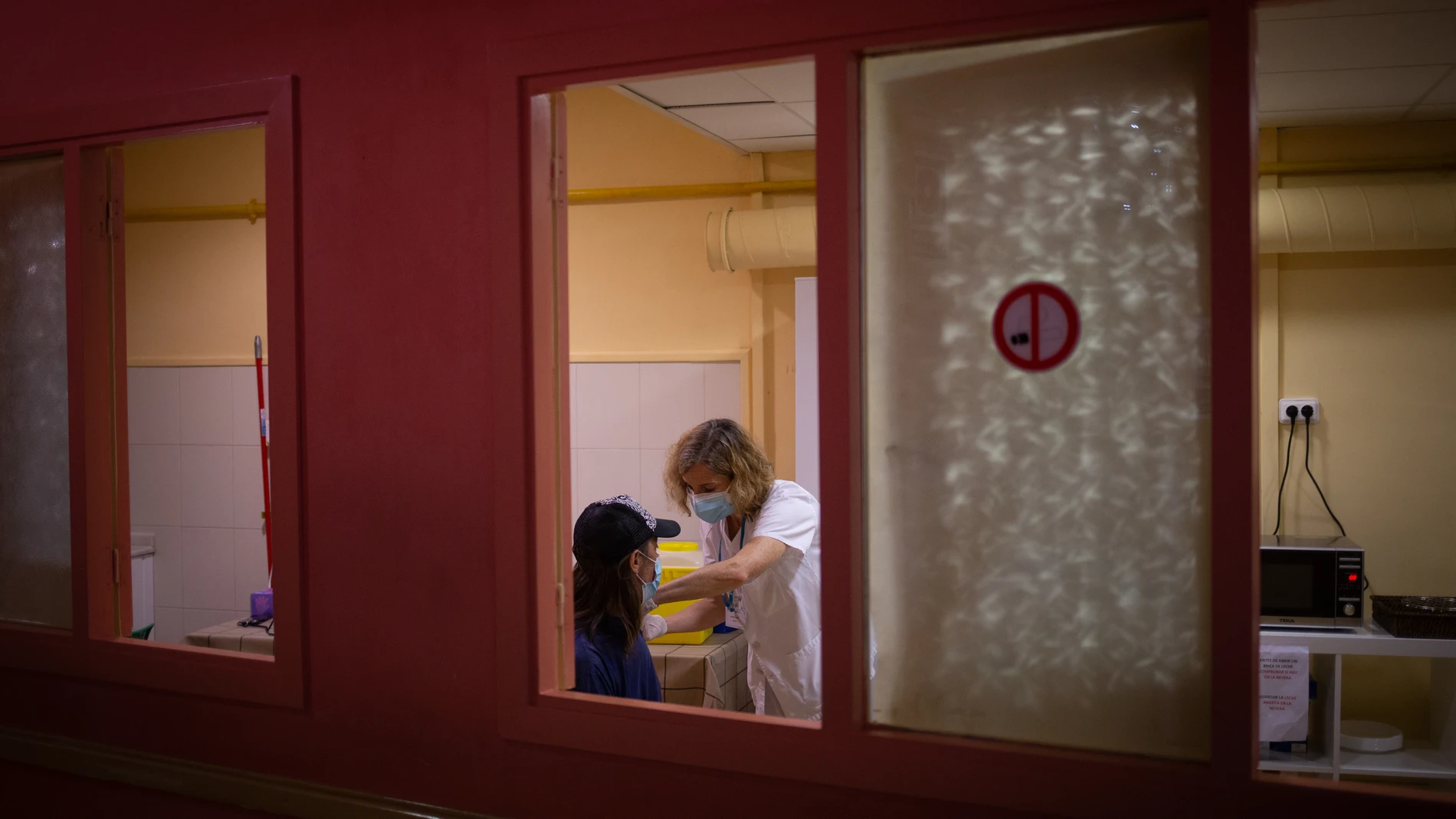 Una sanitaria vacuna a una mujer sin hogar, en la jornada de vacunación a personas sin hogar en el centro abierto de la Fundació Arrels.David Zorrakino / Europa Press