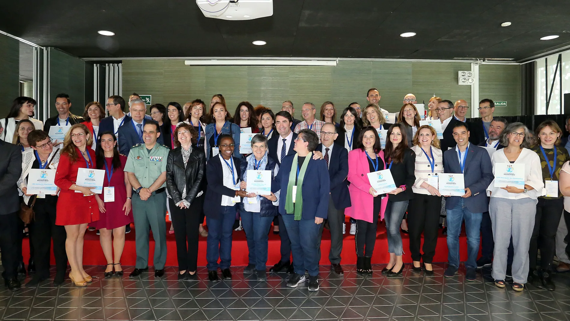 El consejero de Fomento y Medio Ambiente, Juan Carlos Suárez-Quiñones, posa junto a galardonados con el sello ambiental 'Centro Educativo Sostenible' en anteriores ediciones