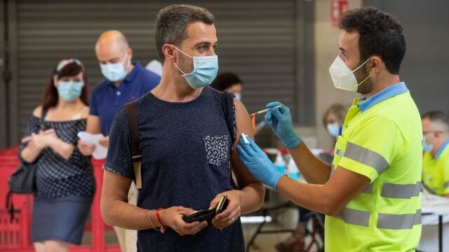 Un enfermero pone la vacuna Pfizer a un hombre en el Estadio Nueva Condomina de Murcia.