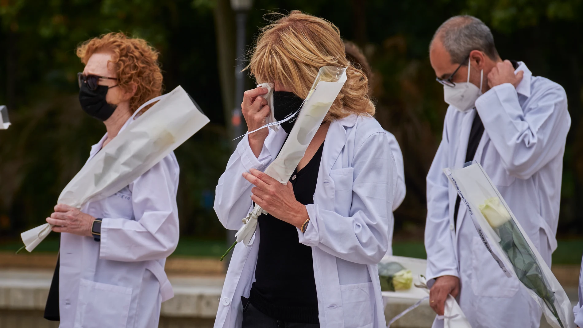 Varios médicos sostienen rosas blancas durante homenaje a los facultativos fallecidos por la covid-19 y a todas las víctimas de la pandemia, en el Templo Debod de Madrid el 5 de junio