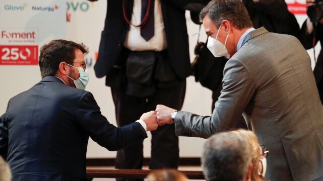 El presidente del Gobierno, Pedro Sánchez, saluda con el puño al presidente de la Generalitat, Pere Aragonès