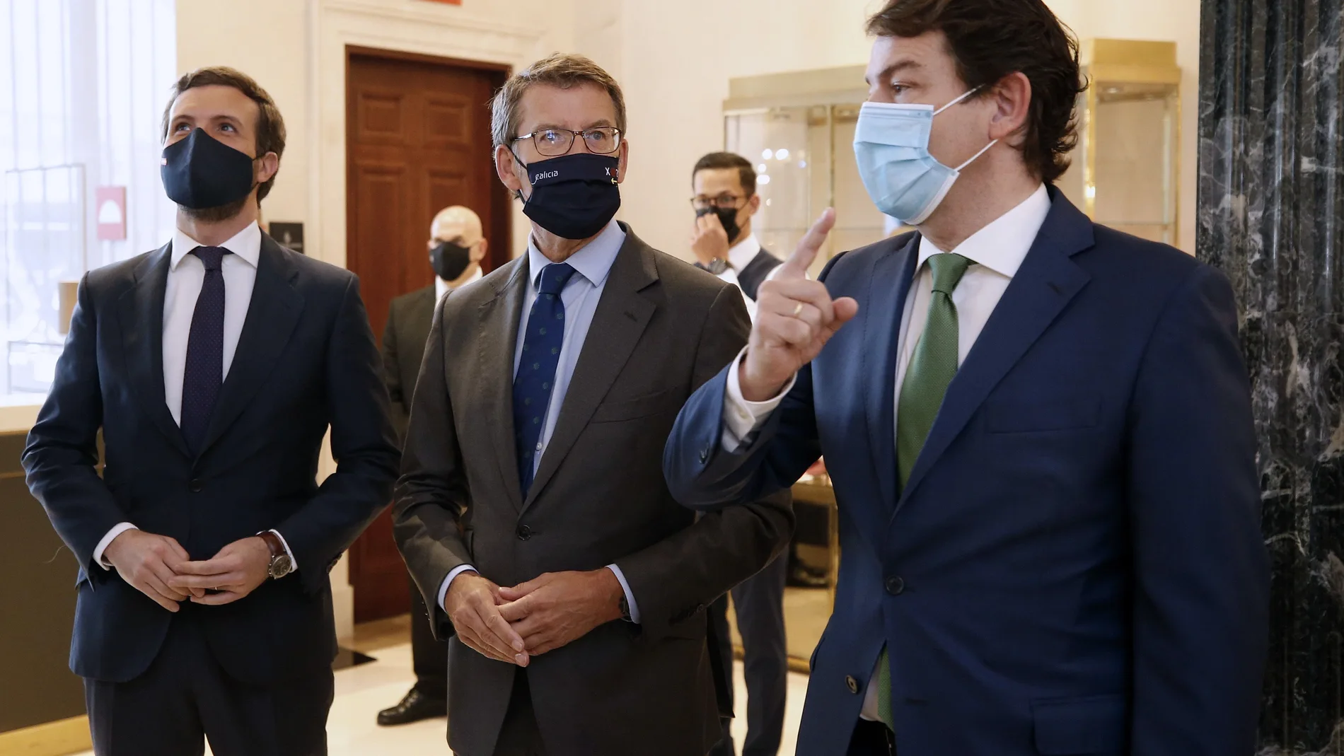 El presidente de la Xunta, Alberto Núñez Feijóo (c), acompañado por el presidente de la Junta de Castilla y León, Alfonso Fernández Mañueco (d), y el presidente del PP, Pablo Casado, a su llegada a un desayuno informativo de Nueva Economía Fórum celebrado este martes en un céntrico hotel de la capital. EFE/Javier Lizón