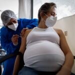 Personal médico aplica una dosis de la vacuna Moderna a una mujer embarazada